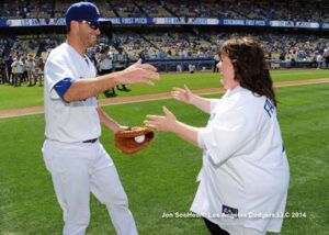 Melissa McCarthy celebrates her first pitch by sharing a hug with Dodger catcher Drew Butera June 28, 2014