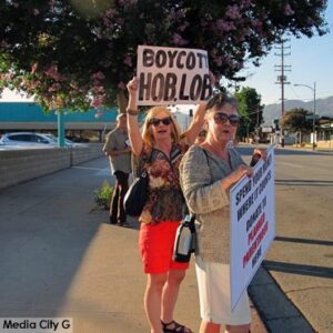 Photo: FLLewis/Media City G -- Protesters waved signs and chanted near the parking lot entrance to the Hobby Lobby in Burbank July 9, 2014